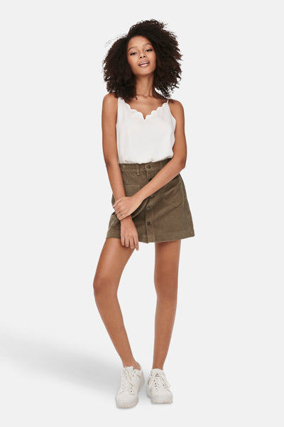 Bruine minirok van corduroy van ONLY, met knopen aan de voorkant, gedragen met een witte tanktop en witte sneakers