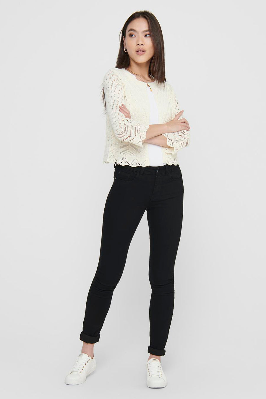 Beige JDY cardigan in openwork knit with three-quarter sleeves, worn over a white t-shirt and black jeans.