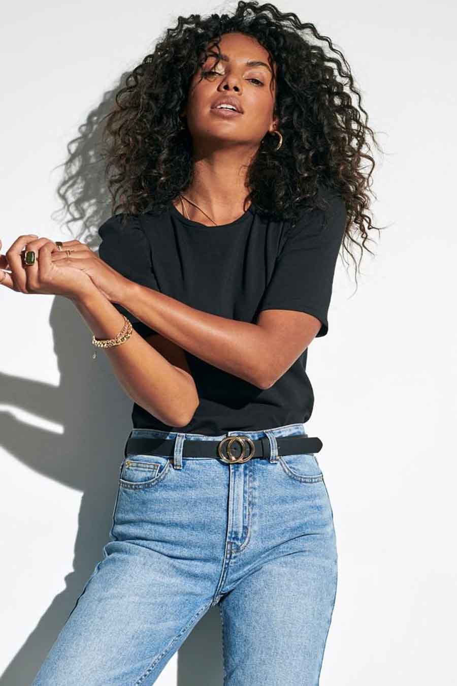 Ceinture noire ONLY®, avec boucle dorée, portée avec un jean taille haute.
