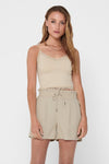 Ecru beha van ONLY, met kant bij de halslijn en dunne bandjes, gedragen met een beige short.
