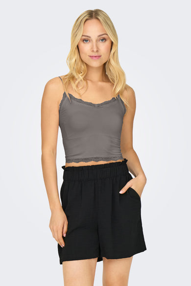 Soutien-gorge gris, de ONLY, avec bordure en dentelle, porté avec un short noir à taille haute.
