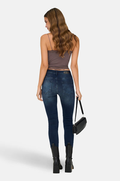 Bruine beha van ONLY, met dunne bandjes en kanten rand, gedragen met een high-waisted jeans en laarzen.
