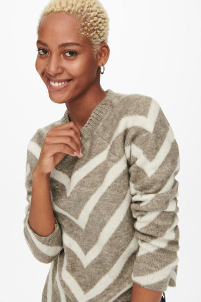 Pull beige à motif chevron par ONLY, porté par une femme souriante.
