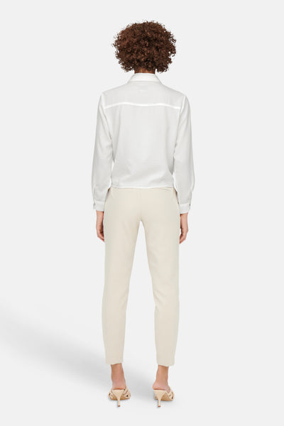 Wit overhemd met lange mouwen van ONLY, van achteren gezien, gedragen met een beige broek en muiltjes met hak.