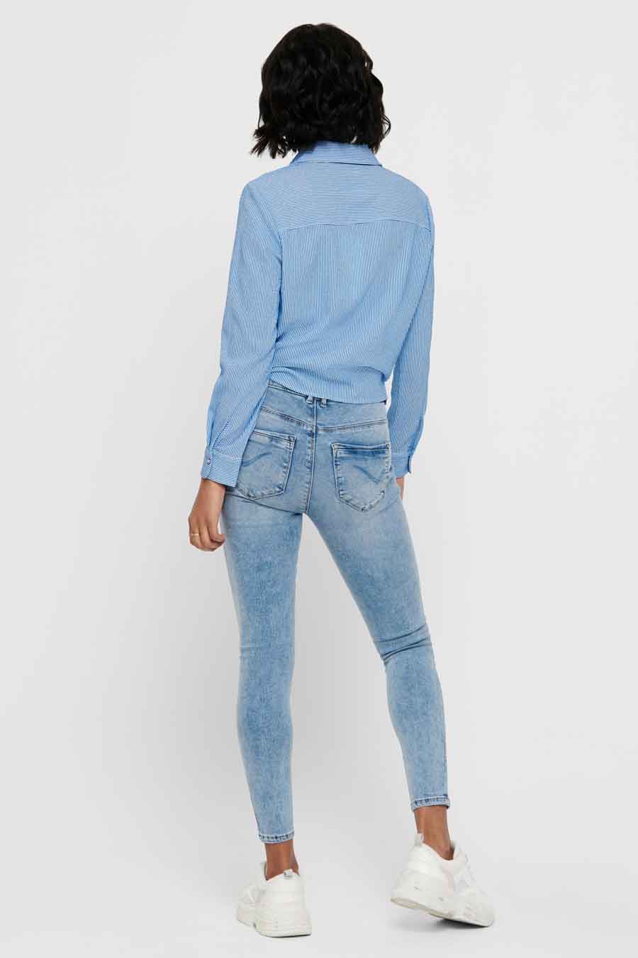 Chemise bleue à rayures by ONLY, vue de dos, portée avec un jean et des baskets blanches.