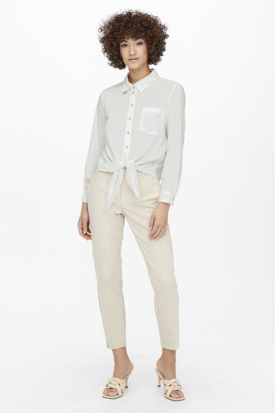 Blauwe blouse met lange mouwen van ONLY®, met strik in de taille, gedragen met een beige broek en muiltjes.