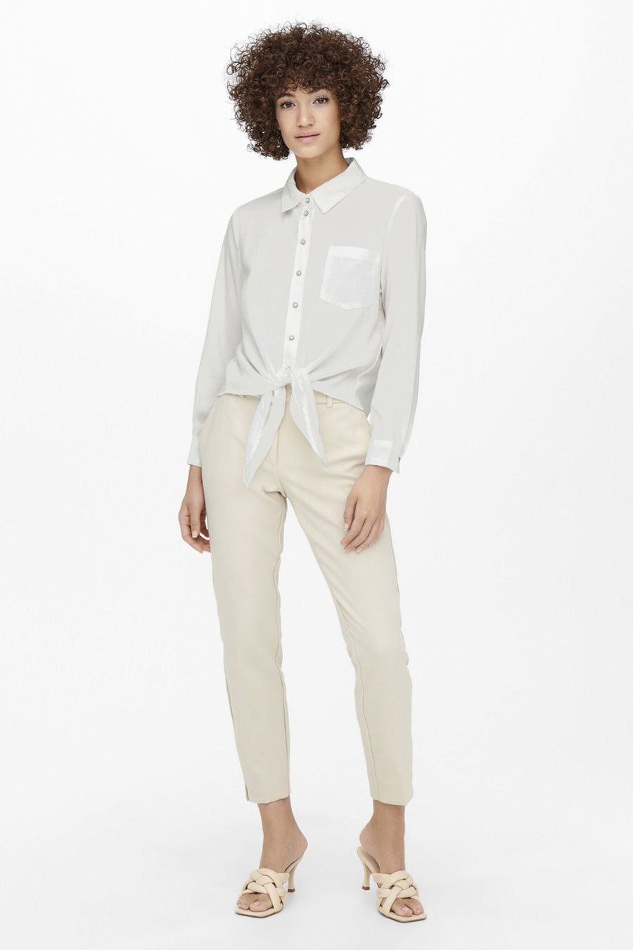 Blauwe blouse met lange mouwen van ONLY®, met strik in de taille, gedragen met een beige broek en muiltjes.