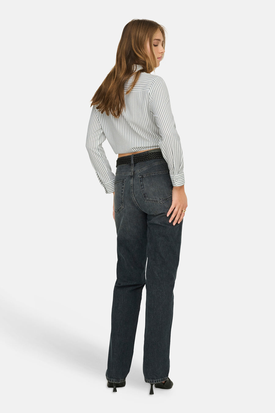Chemise à manches longues rayée multicolore de ONLY®, portée avec un jean taille haute et des talons noirs.
