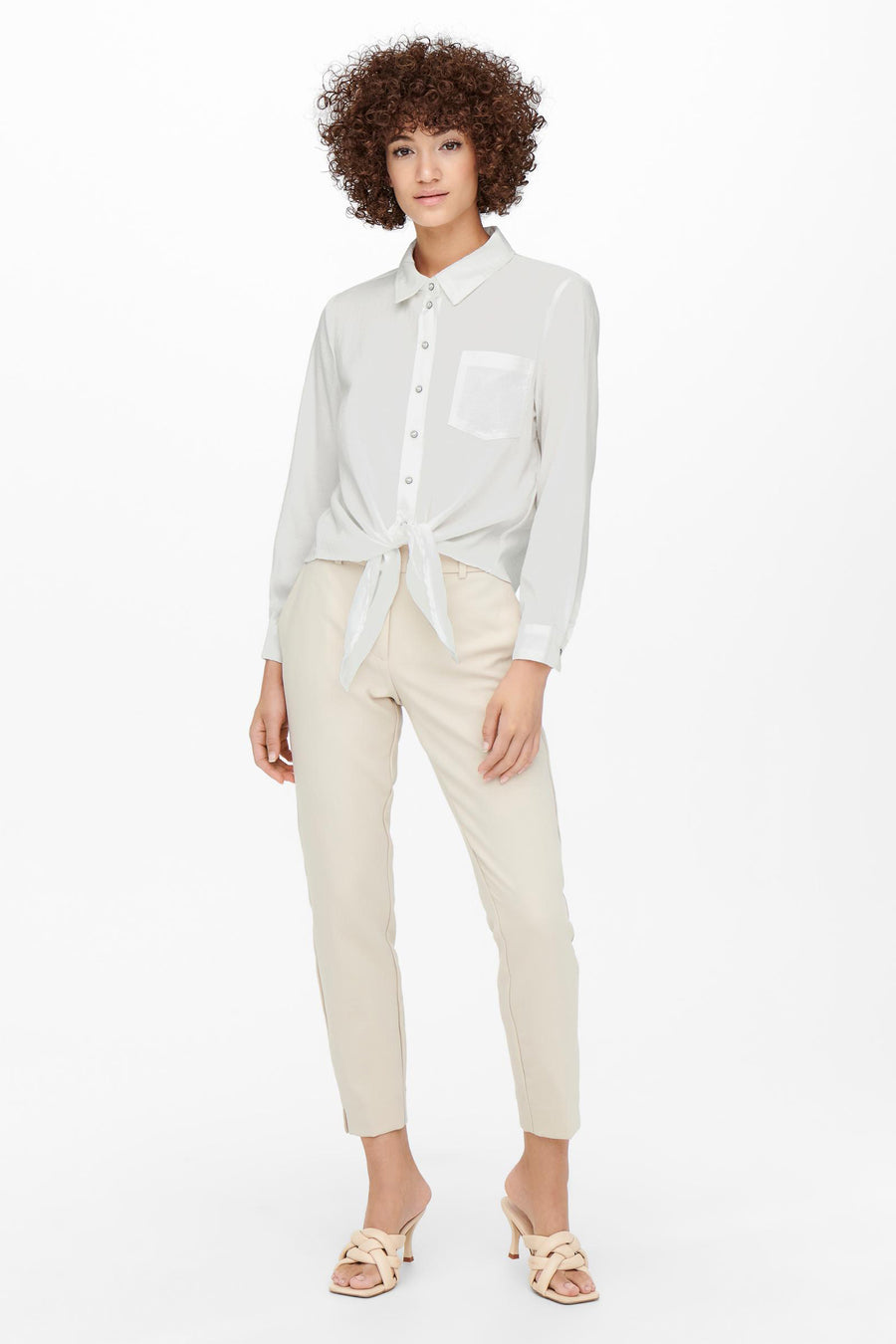 Blauwe blouse met lange mouwen van ONLY, met strik in de taille, gedragen met een beige broek en muiltjes met hak.