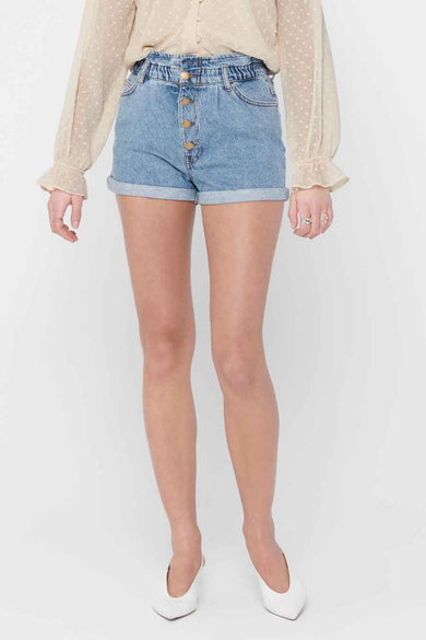 Short en jean bleu de ONLY, porté avec un chemisier à pois et des chaussures blanches