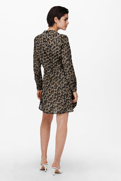 Black and beige patterned midi dress with long sleeves and belted waist, back view, worn with white heels