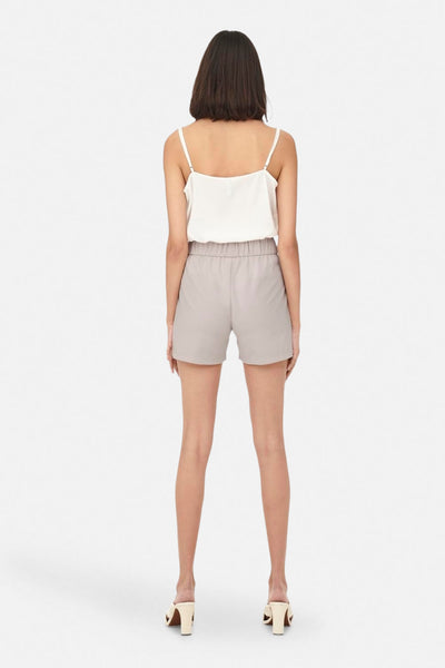 Short gris de JDY, avec une taille élastiquée, porté avec un haut blanc à bretelles.
