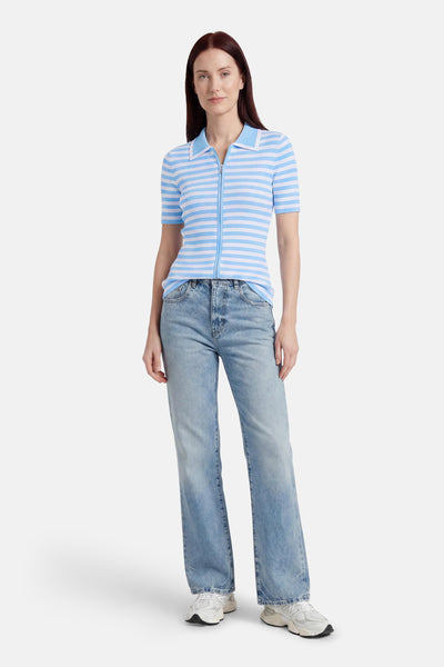Pull côtelé rayé bleu et blanc de GOA GOA, à col polo et fermeture éclair, porté avec un jean et des baskets.