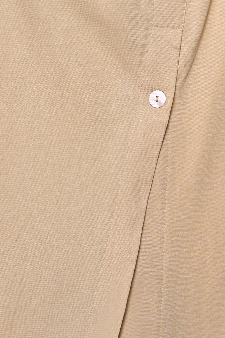 Beige blouse van GOA GOA in getextureerde stof, met een parelmoeren knoop en een overlappende plooi.