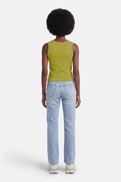 Top vert sans manches de GOA GOA, porté de dos avec un jean bleu clair et des baskets.