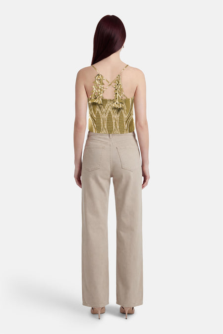 GOA GOA mouwloze top met geometrische patronen, gekruiste bandjes en een beige broek met hoge taille.