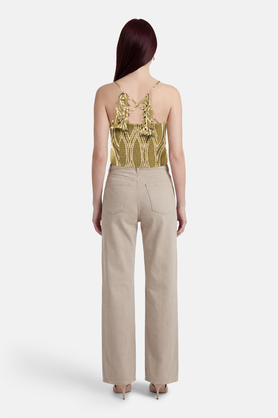 GOA GOA mouwloze top met geometrische patronen, gekruiste bandjes en een beige broek met hoge taille.