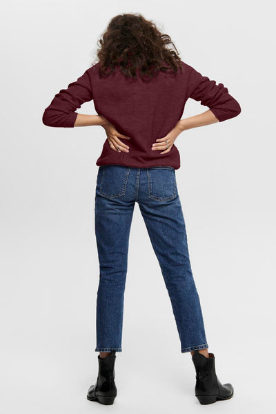 Pull à col en V bordeaux par ONLY, porté avec un jean bleu et des bottines noires, vue de dos.