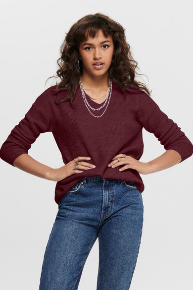 Pull bordeaux à col en V de ONLY, porté avec des jeans bleu moyen et des colliers argentés.