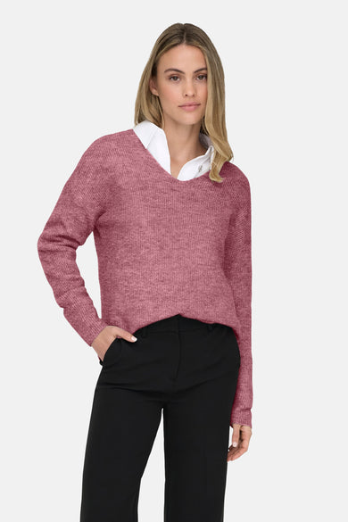 Roze V-hals trui van ONLY, gedragen over een wit overhemd, met een zwarte broek.