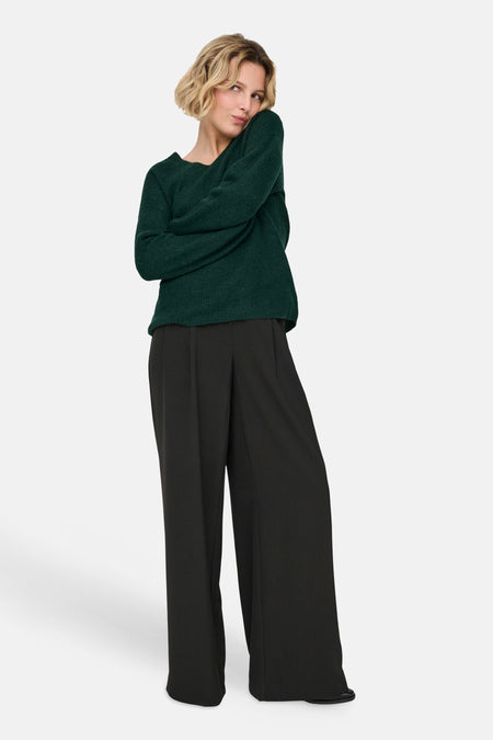 Pull col V vert foncé ONLY® porté avec un pantalon noir large
