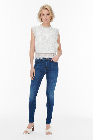 Blouse sans manches écrue de ONLY, avec détails en dentelle et ourlet festonné, portée avec un jean skinny.
