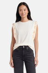 Beige T-shirt met korte mouwen van GOA GOA met gouden paillettenbanden op de schouders, gedragen met een donkere spijkerbroek.