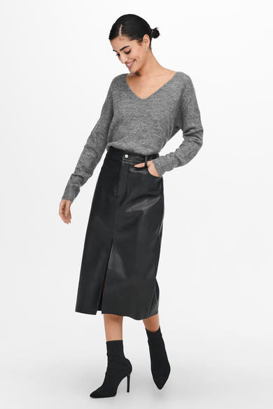Pull à col rond gris de JDY, porté avec une jupe crayon en similicuir noir et des bottines à talons aiguilles noires.