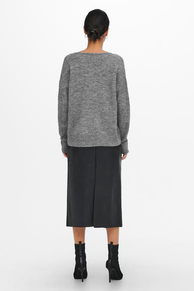 Pull à col rond gris de JDY, porté avec une jupe midi noire et des bottines noires à talons aiguilles.