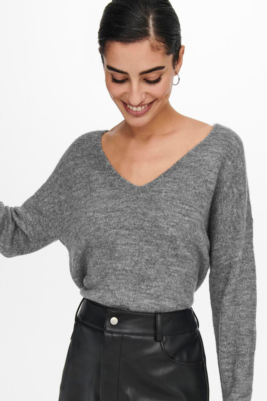 Pull col rond gris de JDY, avec un col en V et une texture douce, porté avec un pantalon noir.
