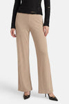 Pantalon de costume beige de GOA GOA, coupe large et fluide, porté avec un haut noir et des escarpins.