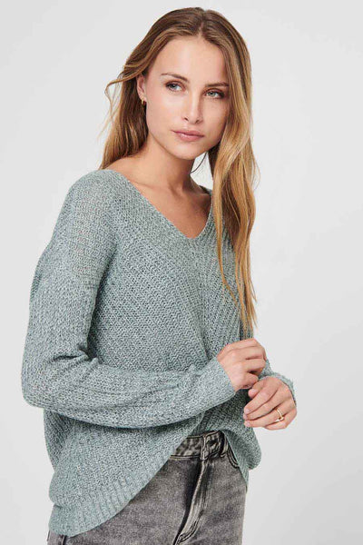 Pull vert à col V de JDY, maille texturée portée avec un jean délavé.
