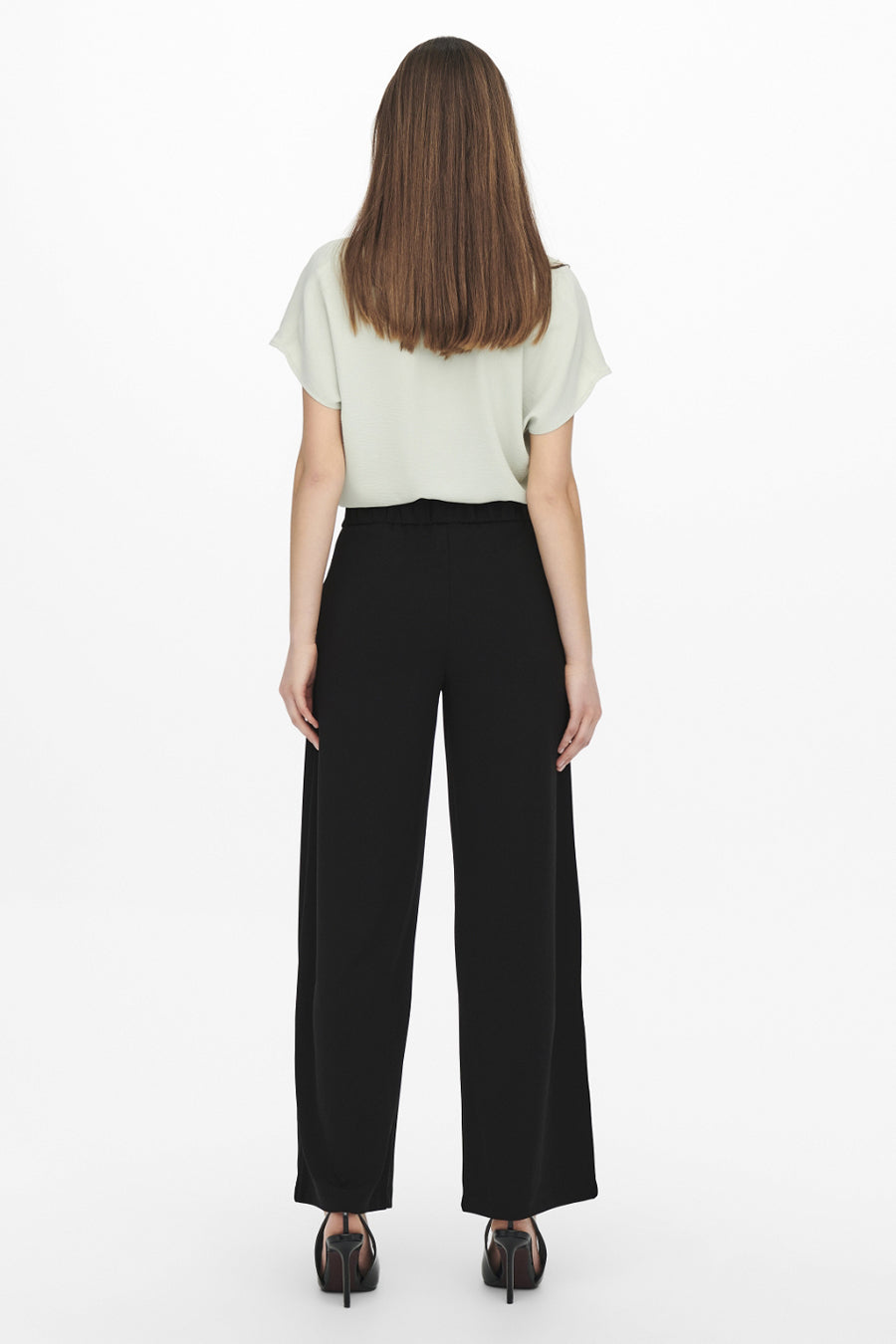 Pantalon de costume noir de JDY, coupe ample, porté avec un haut vert et des chaussures à talons noirs.