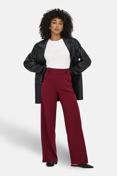 Pantalon de costume rouge de JDY, porté avec un t-shirt blanc et un blazer en similicuir.