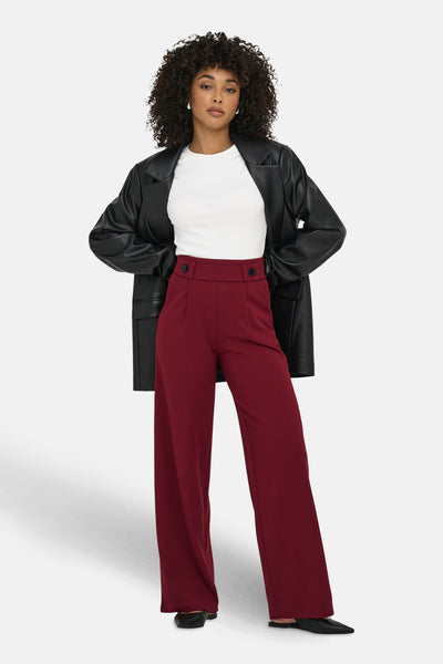Pantalon de costume rouge de JDY, porté avec un t-shirt blanc et un blazer en similicuir.