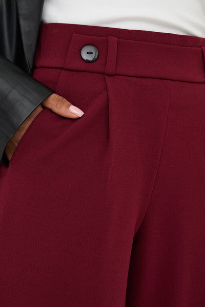 Pantalon de costume rouge de JDY, avec une main dans la poche et un bouton.