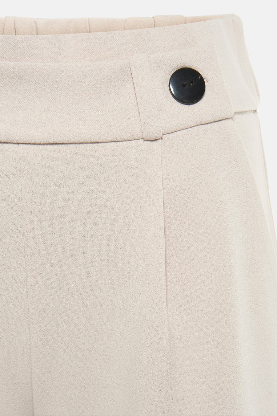 Pantalon de costume beige par JDY, avec fermeture à bouton noir apparent sur la ceinture.
