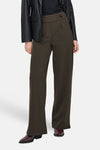 Bruine pantalon de costume van JDY, met een hoge taille en een wijde pijp, gedragen met een zwarte blouse en een leren blazer.