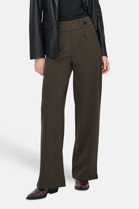 Pantalon de costume brun de JDY, à jambes larges, avec un bouton décoratif à la taille et porté avec une veste noire.