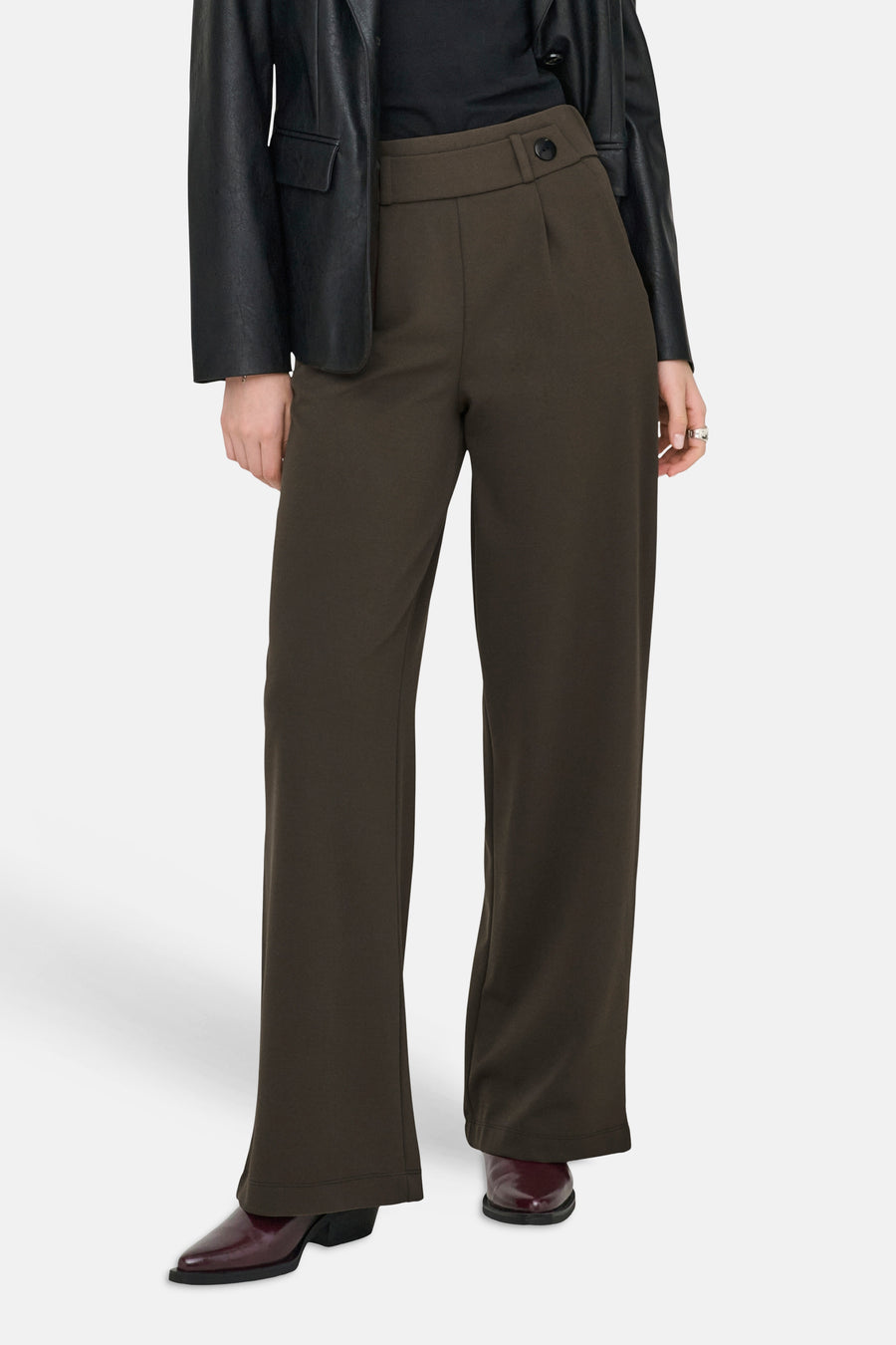 Bruine pantalon de costume van JDY, met een hoge taille en een wijde pijp, gedragen met een zwarte blouse en een leren blazer.