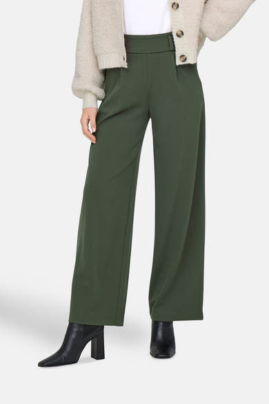 Pantalon de costume kaki de JDY, coupe ample et jambe large, porté avec des bottines noires à talons.
