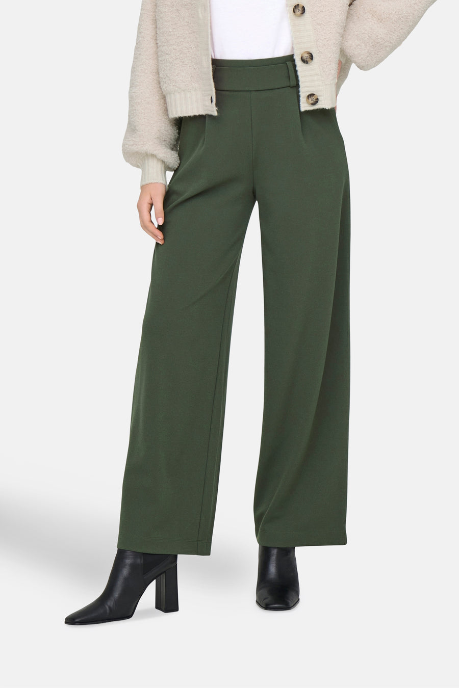 Pantalon de costume kaki de JDY, coupe ample et jambe large, porté avec des bottines noires à talons.
