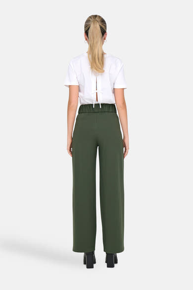 Pantalon de costume kaki de JDY, avec taille élastique et jambes larges, porté avec un t-shirt blanc à dos noué.