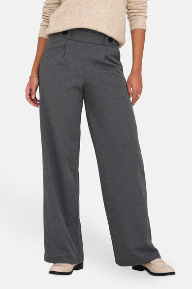 Pantalon de costume gris par JDY, coupe ample à jambes larges, porté avec un pull beige et des mocassins.