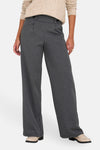 Pantalon de costume gris par JDY, coupe ample à jambes larges, porté avec un pull beige et des mocassins.