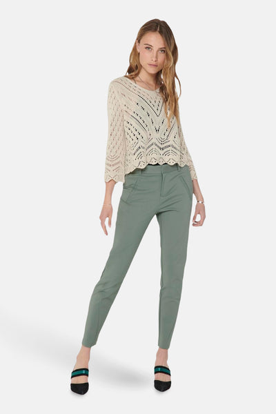 Pull col V beige de JDY, en maille ajourée avec un col en V plongeant, porté avec un pantalon vert olive.
