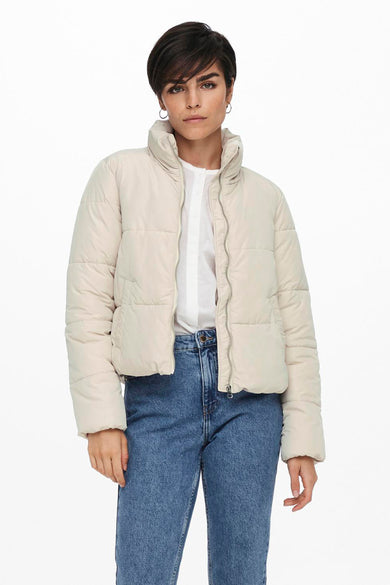 Veste courte écrue de JDY, portée avec une chemise blanche ouverte et un jean bleu.