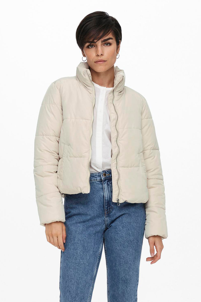Veste courte écrue de JDY, portée avec une chemise blanche ouverte et un jean bleu.
