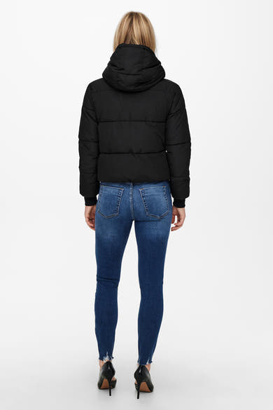 Veste courte noire de JDY, portée avec un jean bleu et des talons aiguilles noirs.