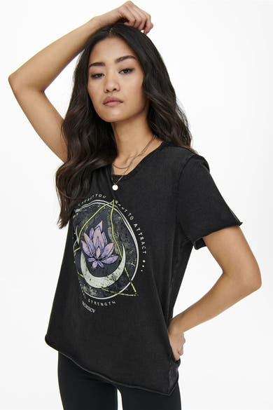 T-shirt noir à manches courtes de ONLY, avec motif lotus, porté avec un collier à pendentif.
